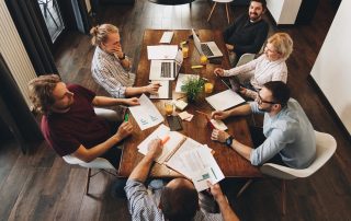 A group of young business team working together on a new project in a modern office with laptops and tablets.
